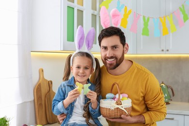 Photo of Father and his daughter with Easter eggs in kitchen