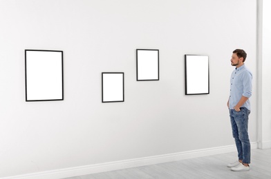 Photo of Man viewing exposition in modern art gallery