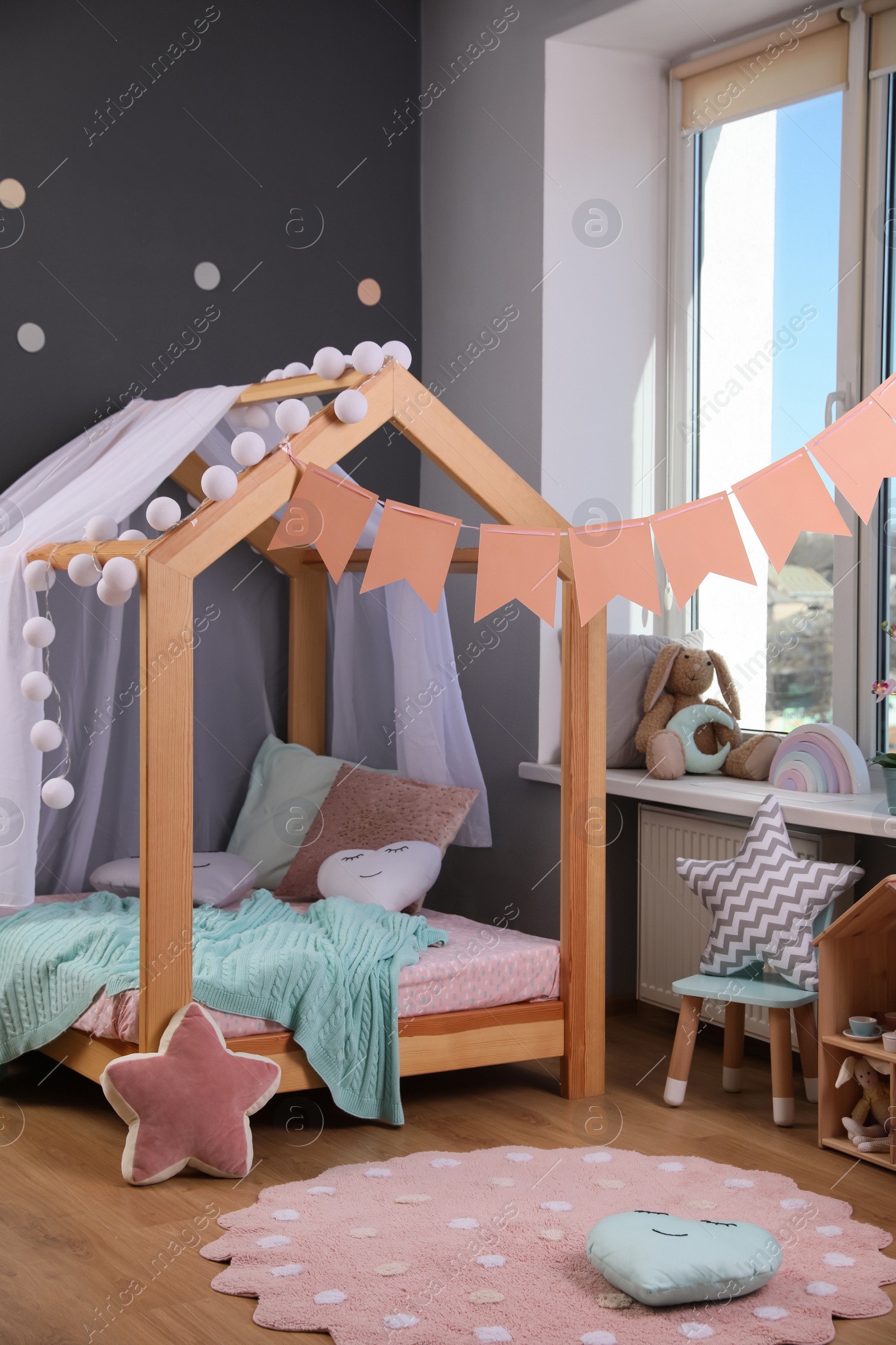 Photo of Stylish child room interior with house bed and different toys