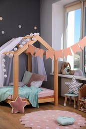 Stylish child room interior with house bed and different toys