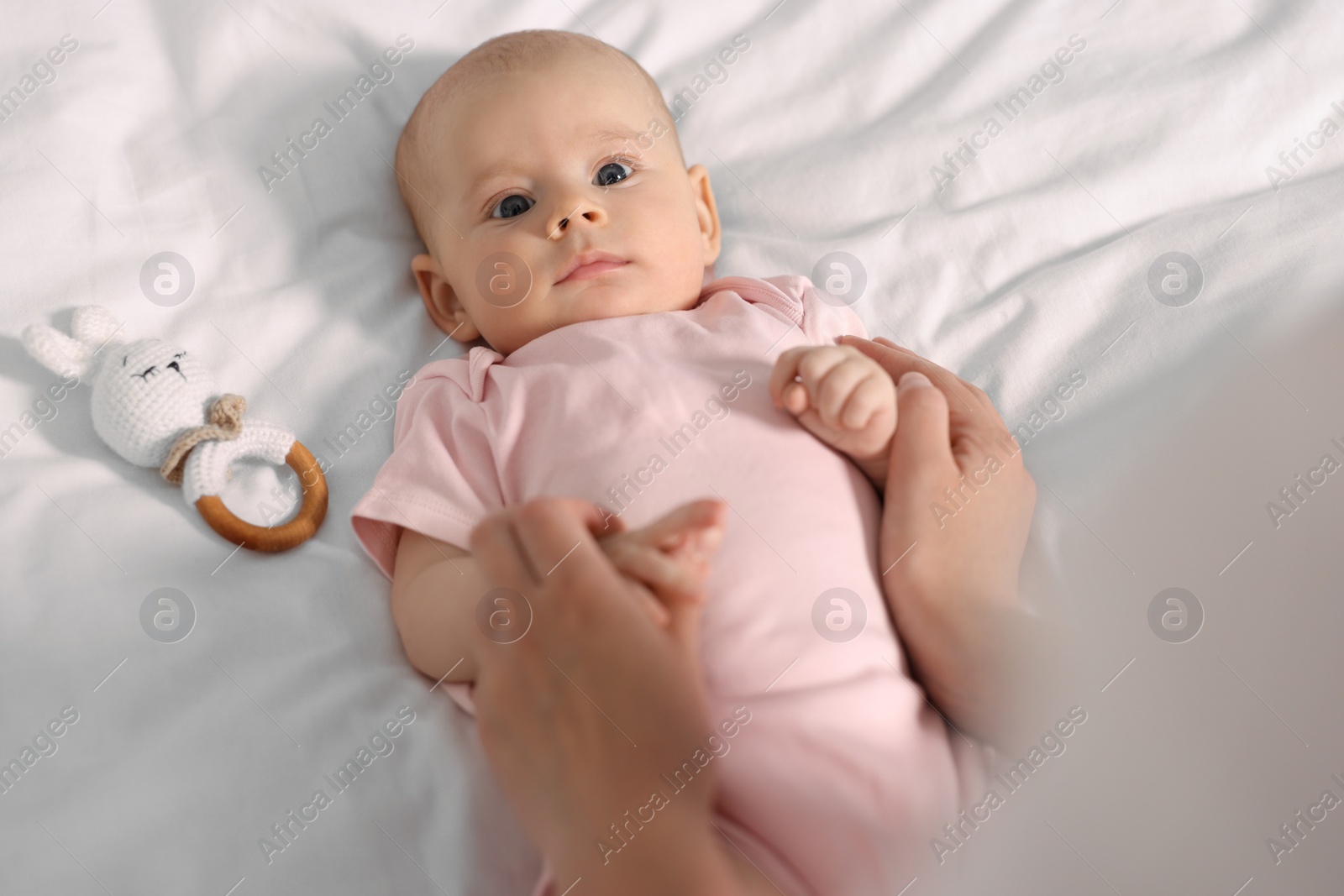 Photo of Mother with her cute little baby on white sheets