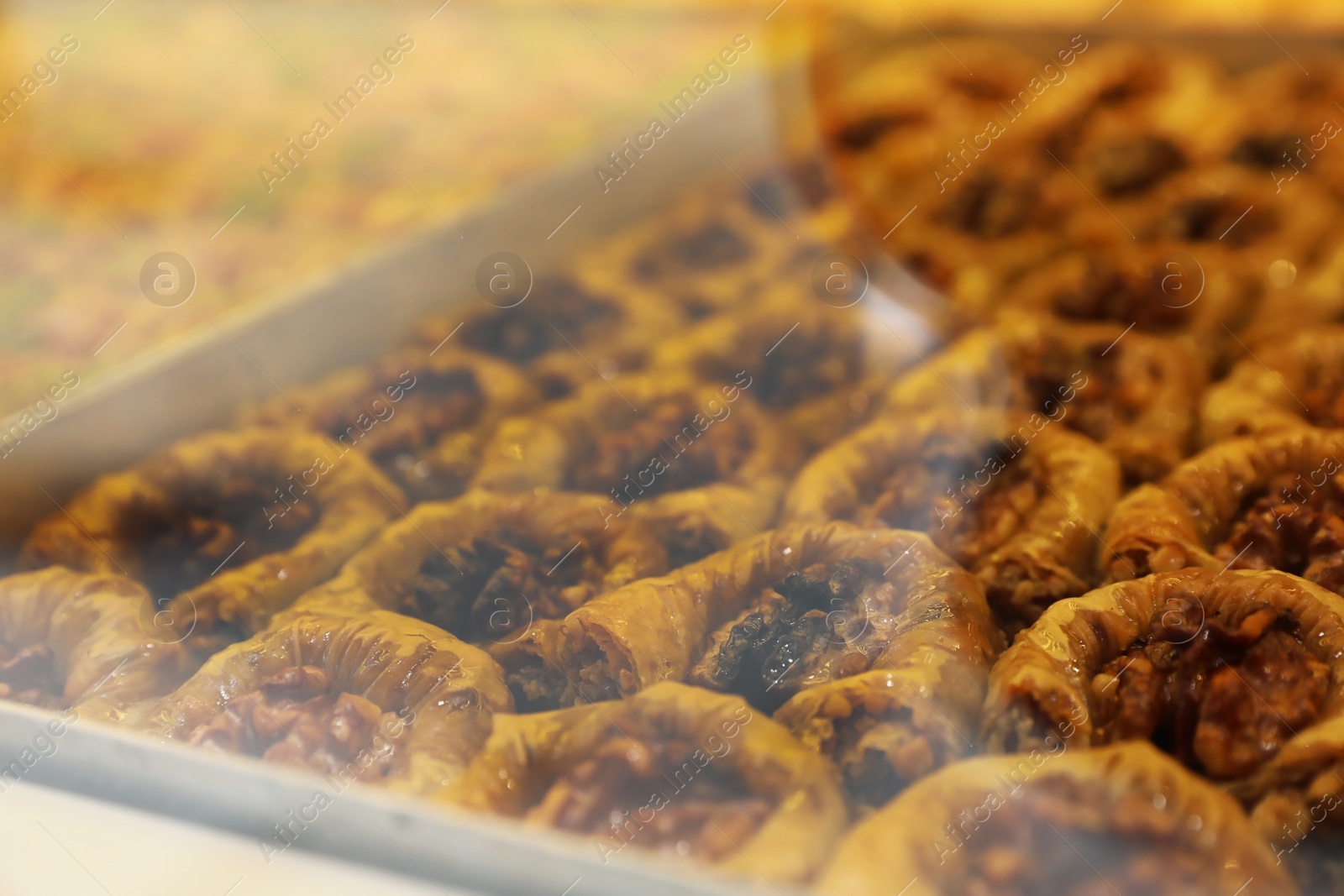 Photo of Closeup view of turkish pastries in shop through window glass