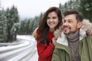 Couple in warm clothes outdoors. Winter vacation