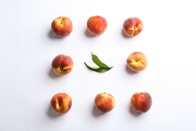 Composition with fresh peaches on white background, top view