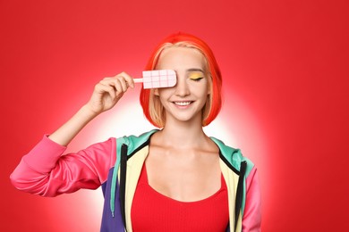 Photo of Beautiful young woman with bright dyed hair holding ice cream on color background