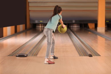 Photo of Little girl throwing ball at bowling club