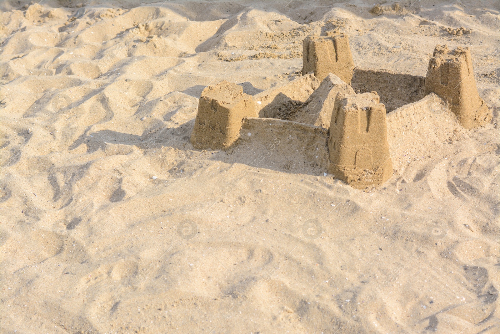 Photo of Beautiful sand castle on beach. Space for text