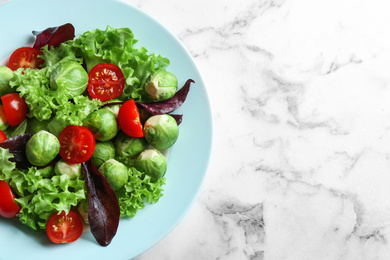 Photo of Tasty salad with Brussels sprouts on white marble table, top view. Space for text