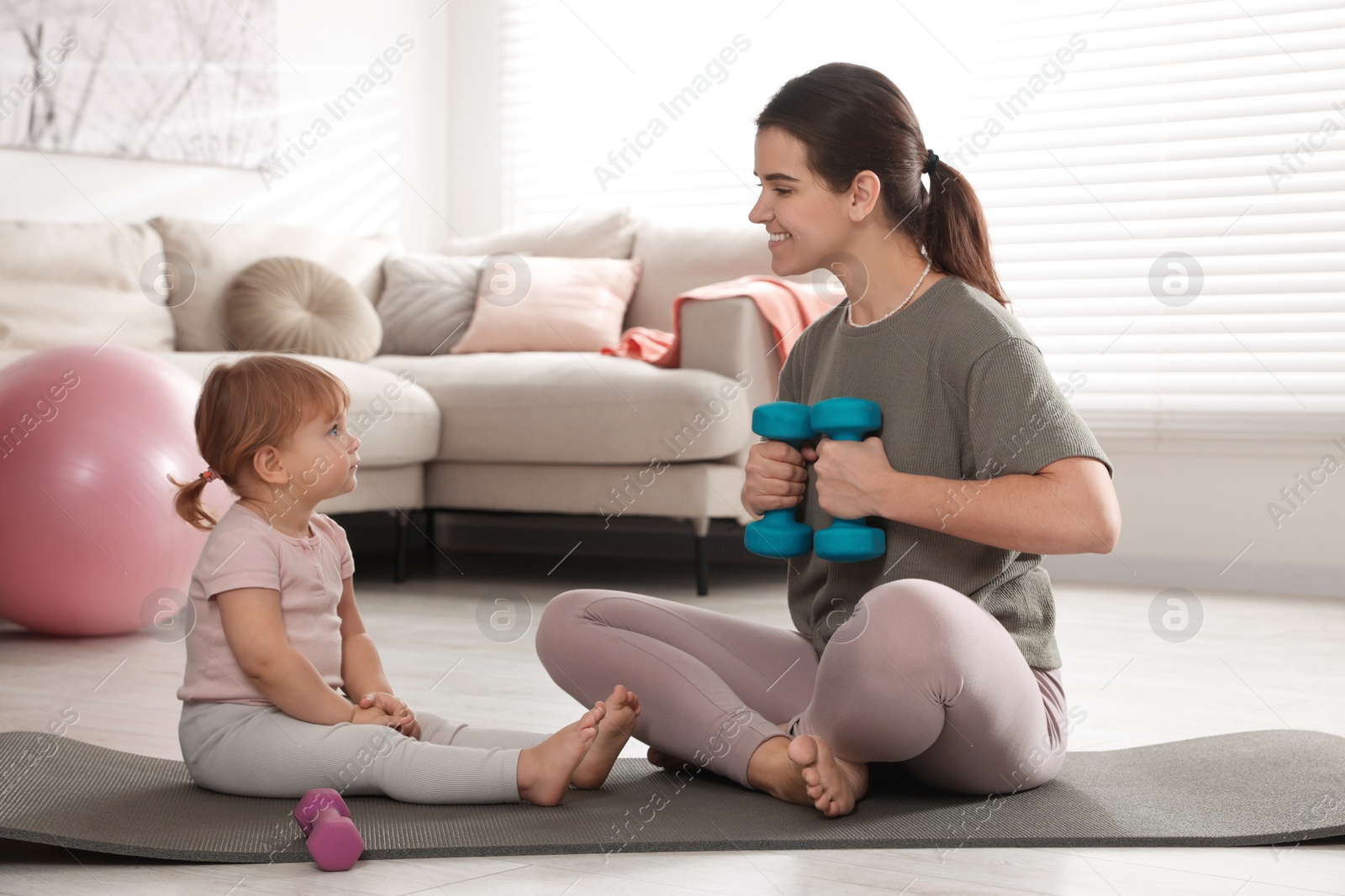 Photo of Mother doing exercise with her daughter at home