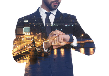 Double exposure of businessman checking time and night city landscape