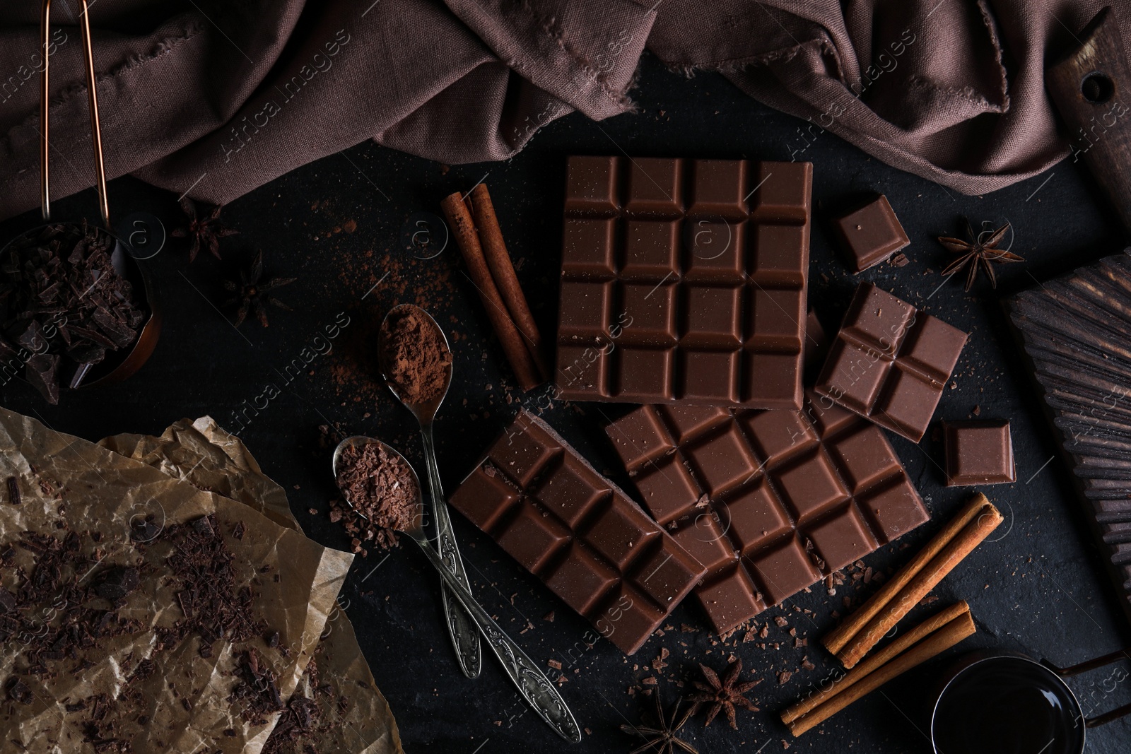 Photo of Flat lay composition with milk chocolate on black table