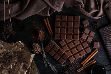 Flat lay composition with milk chocolate on black table