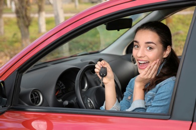 Photo of Happy woman showing key from new car
