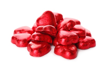 Photo of Heart shaped chocolate candies in red foil on white background