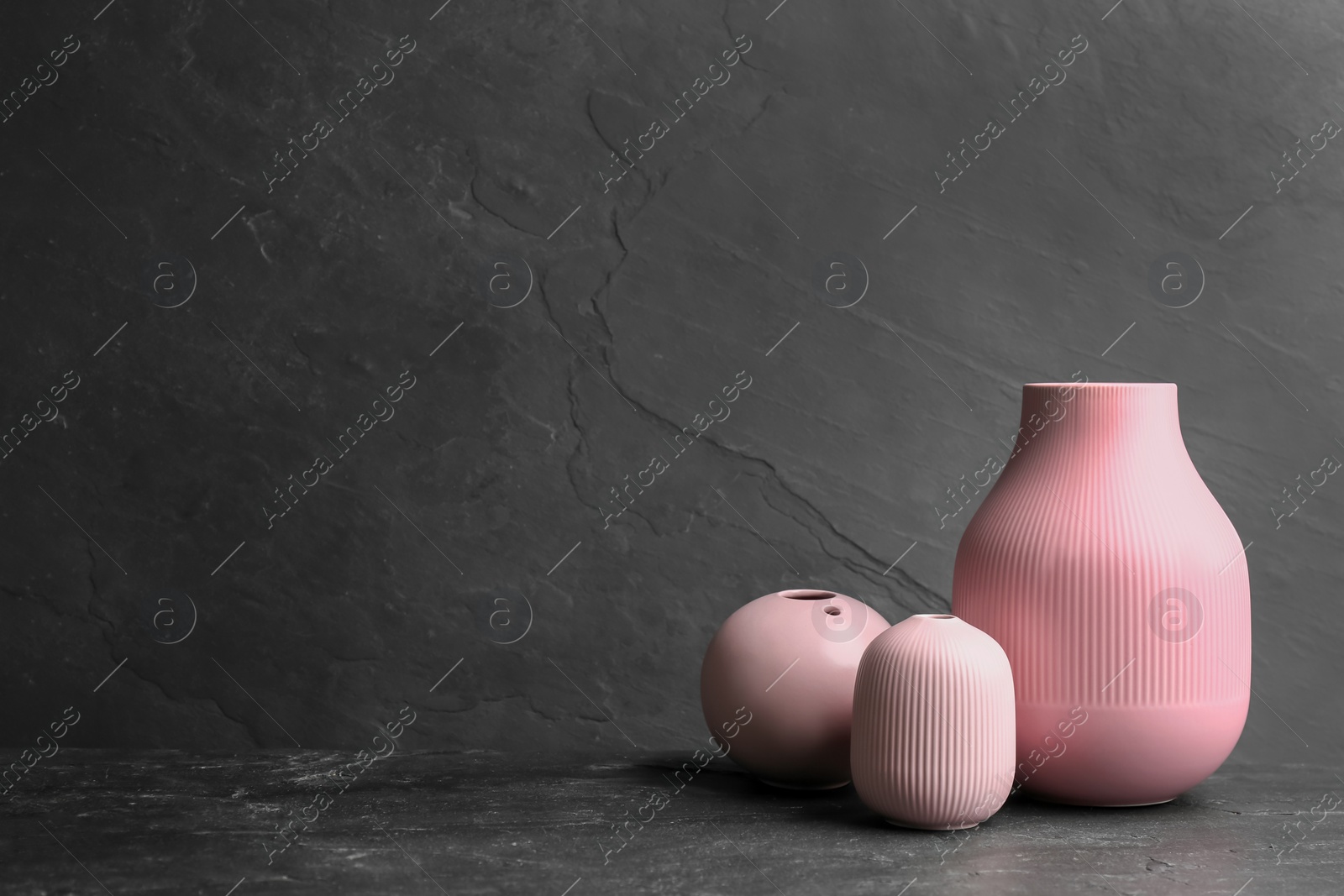 Photo of Stylish empty ceramic vases on black table, space for text