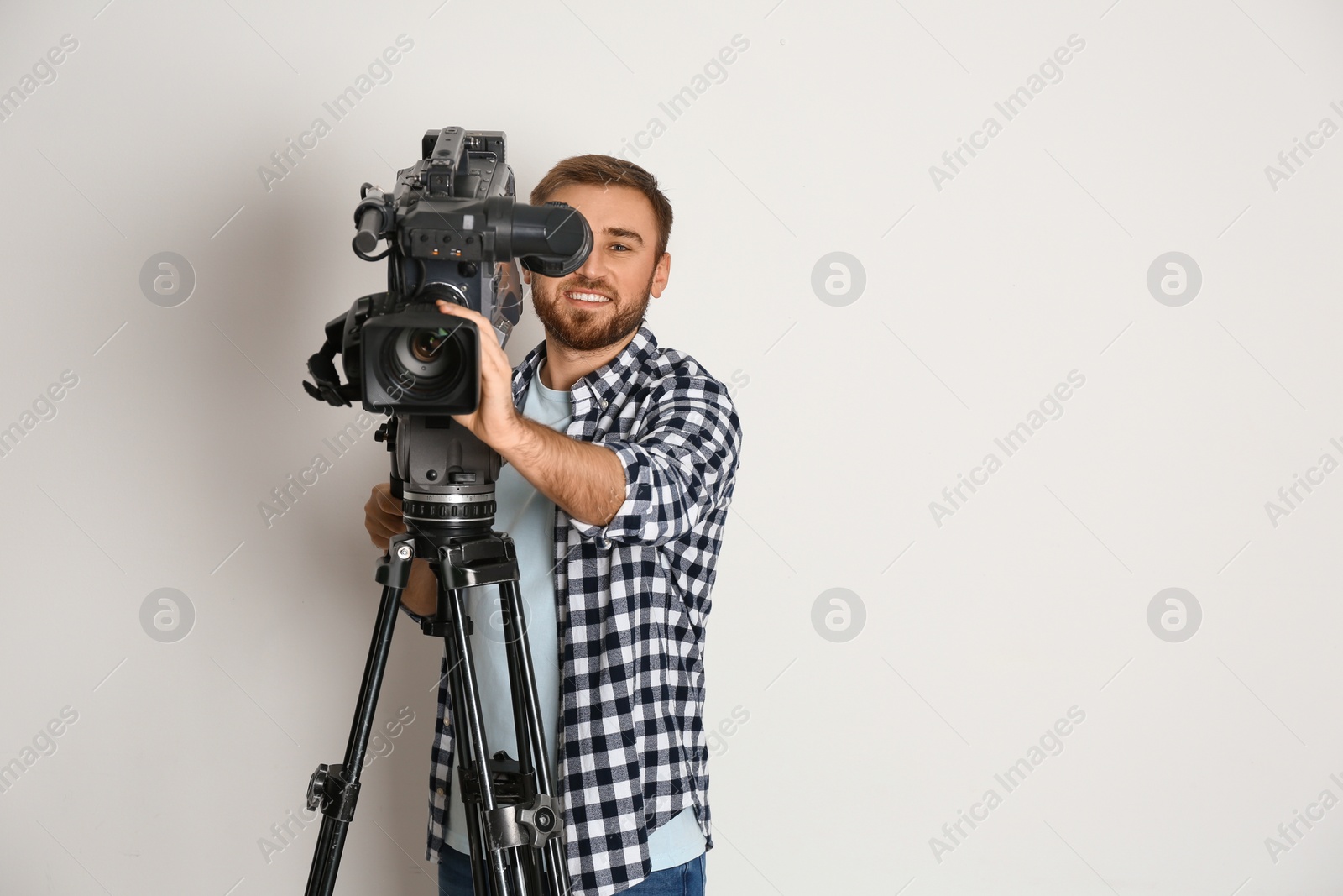Photo of Operator with professional video camera on white background, space for text