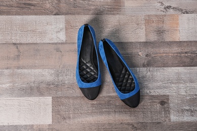 Pair of female shoes on wooden background, top view