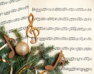 Photo of Composition with wooden music notes and decorations on sheets, top view