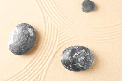 Photo of Zen concept. Stones and pattern on beige sand, flat lay