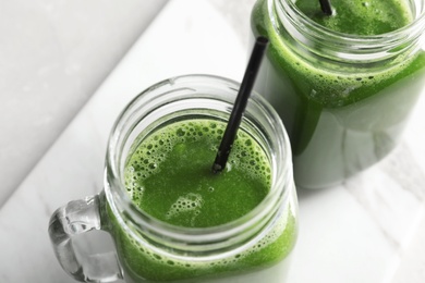 Mason jars with delicious detox juice on table