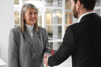 Lawyer shaking hands with client in office