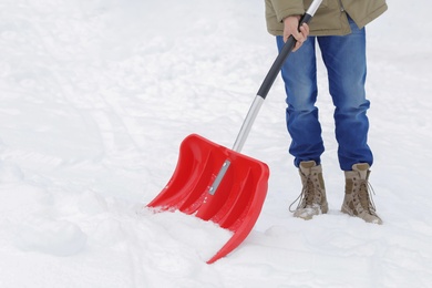 Man removing snow with shovel outdoors. Winter weather