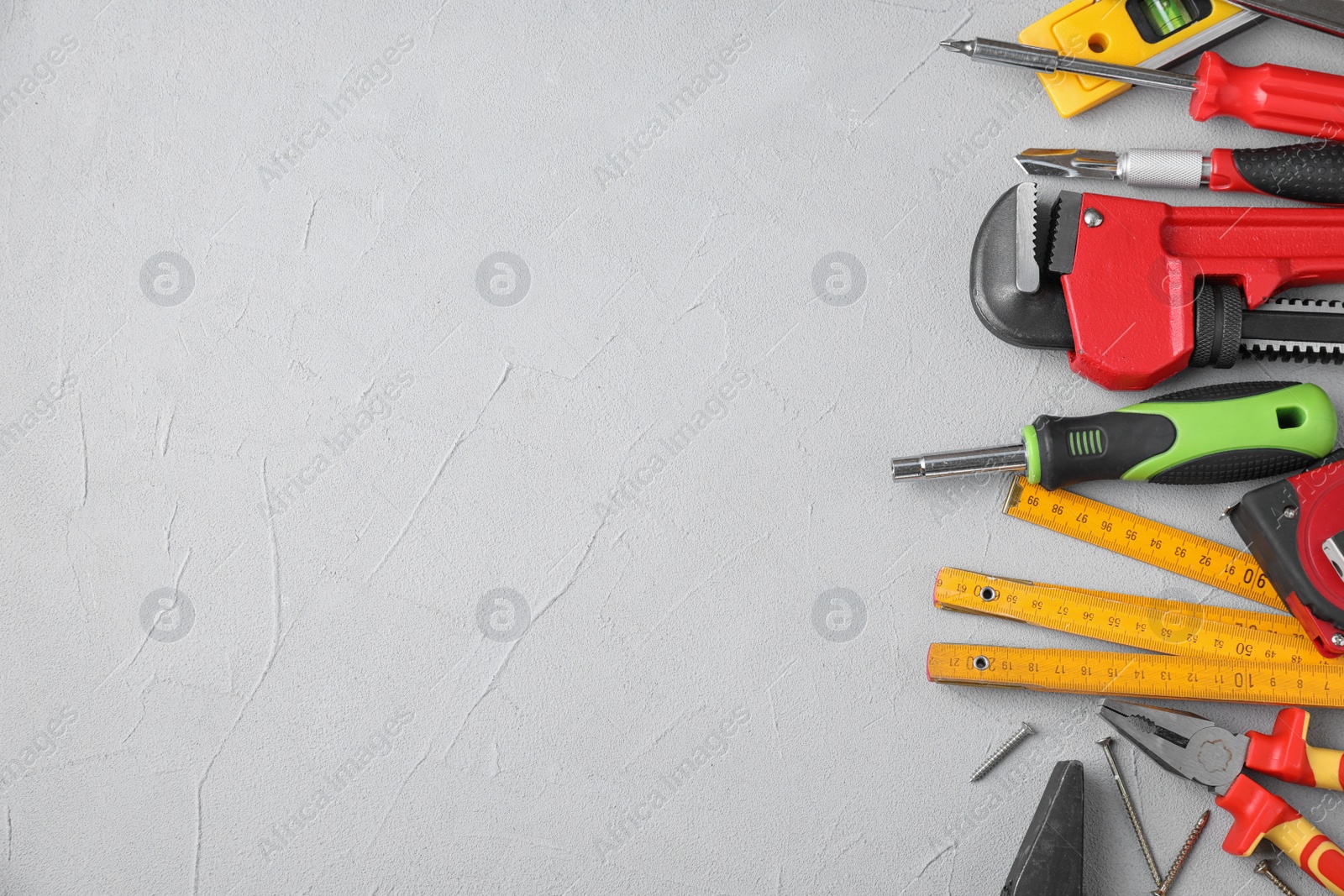 Photo of Flat lay composition with construction tools on light grey background. Space for text