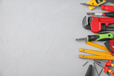 Flat lay composition with construction tools on light grey background. Space for text