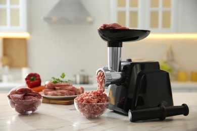 Photo of Modern meat grinder and products on white marble table in kitchen. Space for text