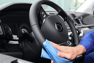 Photo of Car wash worker cleaning automobile interior, closeup