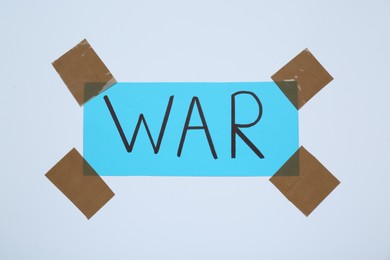 Photo of Word War attached with adhesive tape on white background
