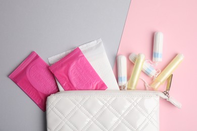 Tampons, pads and bag on color background, flat lay
