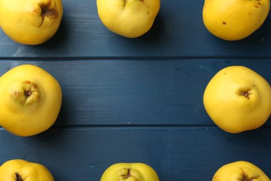 Tasty ripe quinces on blue wooden table, flat lay. Space for text