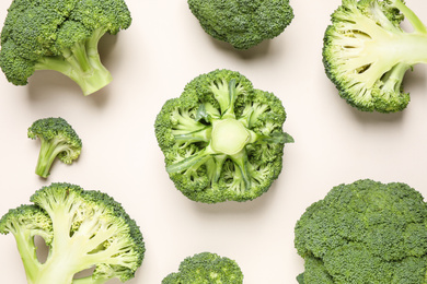 Photo of Fresh tasty broccoli on light beige background, flat lay