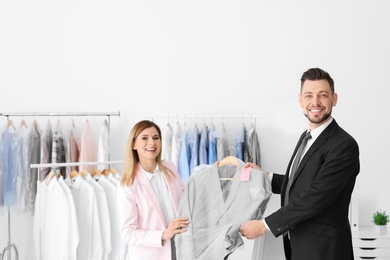 Photo of Young businessman receiving his jacket at dry-cleaner's