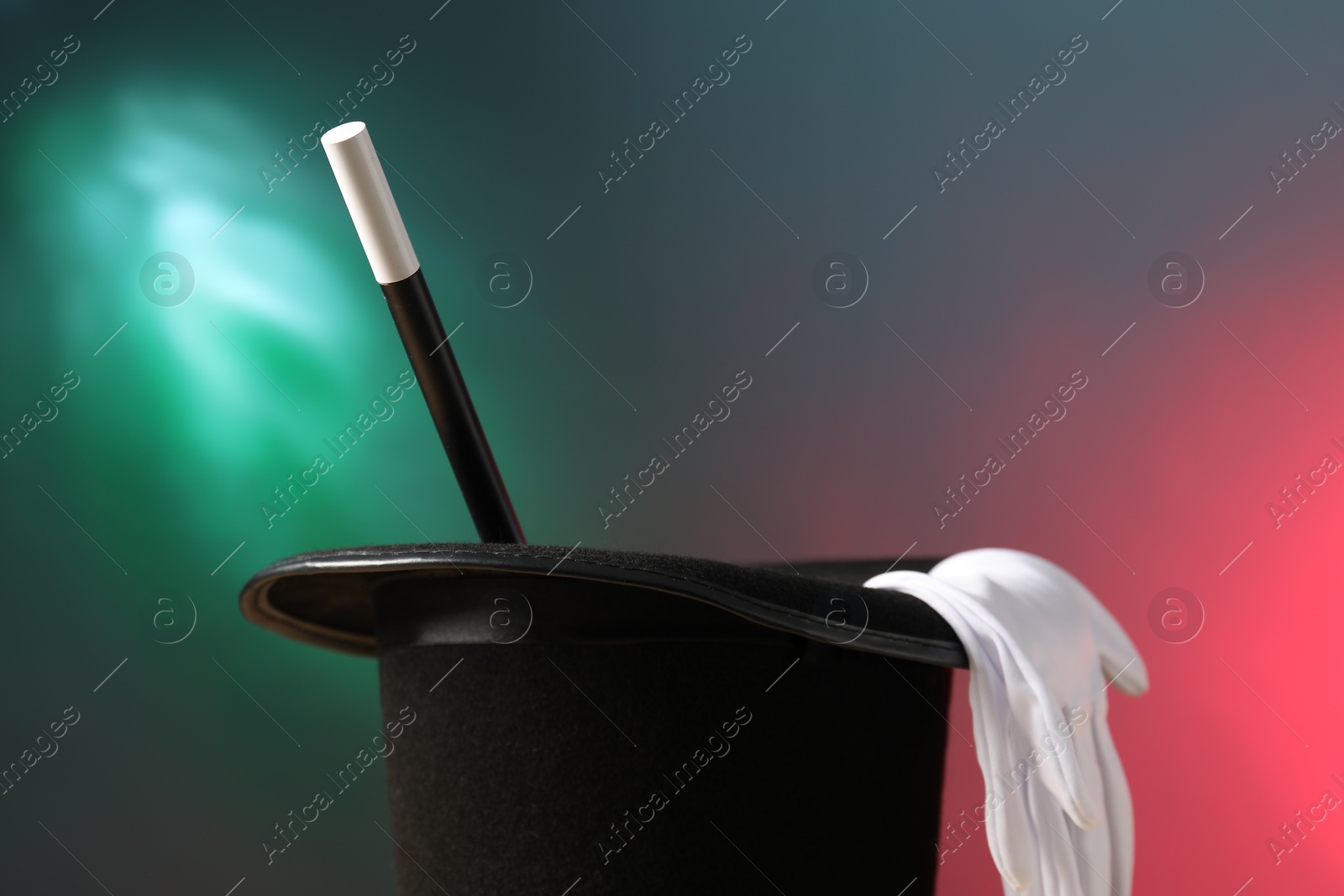 Photo of Magician's hat, wand and gloves on color background, space for text