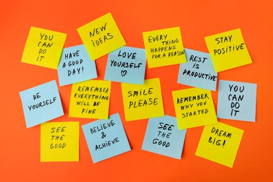 Photo of Paper notes with life-affirming phrases on orange background