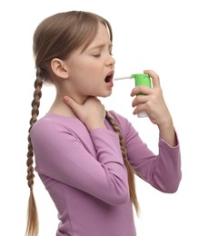 Photo of Little girl using throat spray on white background