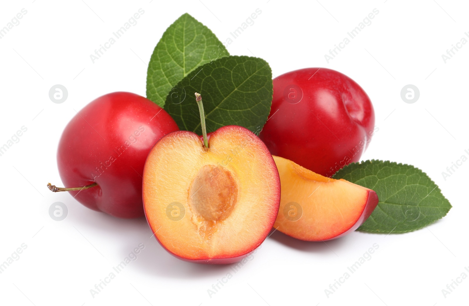 Photo of Cut and whole cherry plums with leaves on white background