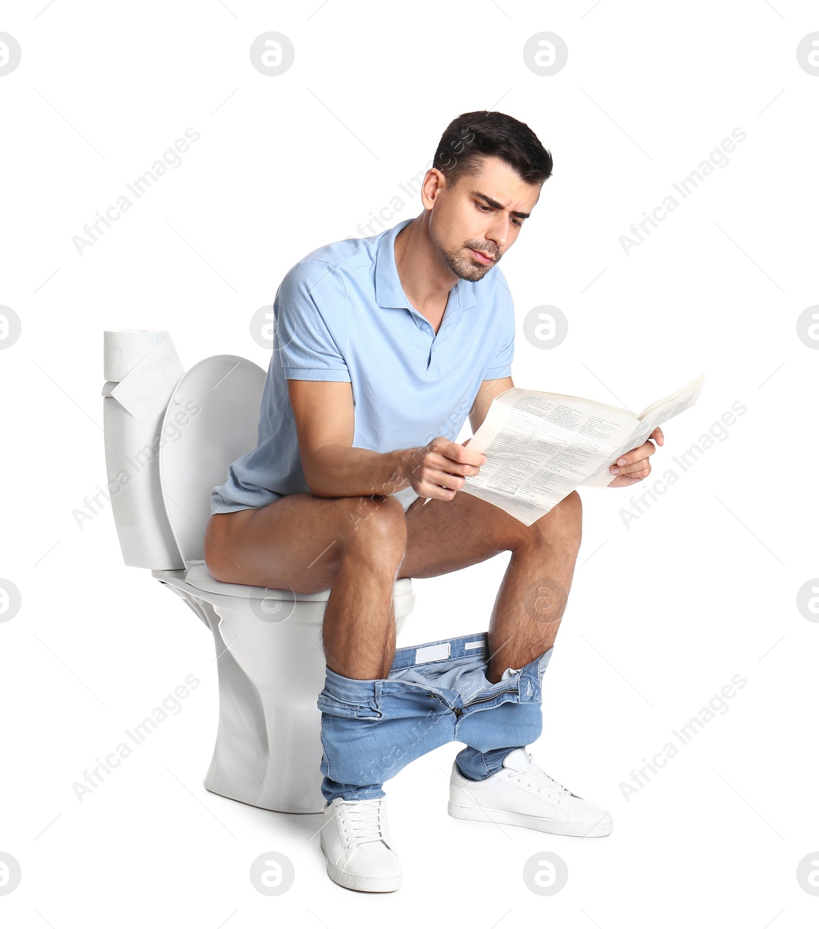 Photo of Man with newspaper sitting on toilet bowl, white background