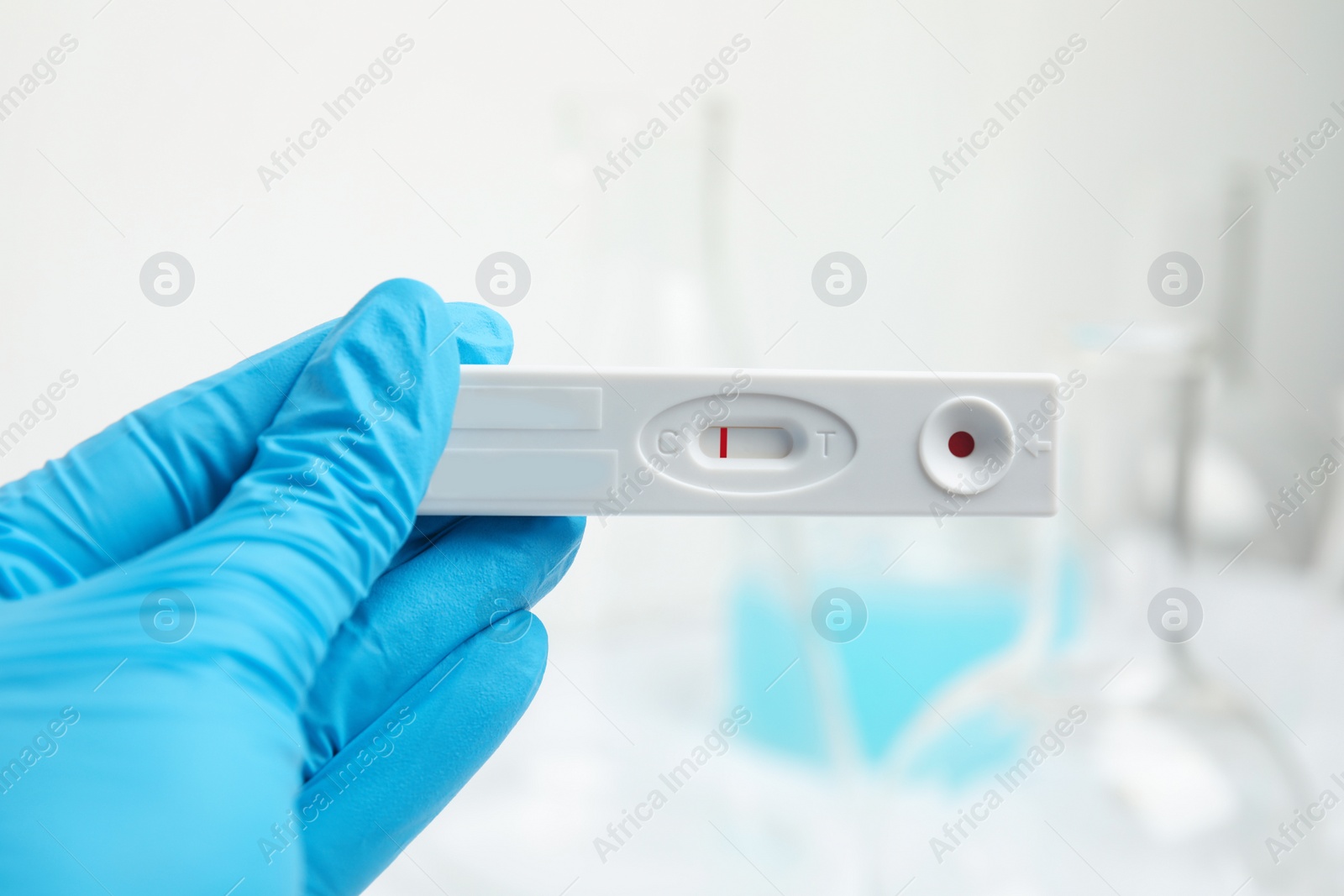 Photo of Doctor holding disposable express test for hepatitis indoors, closeup