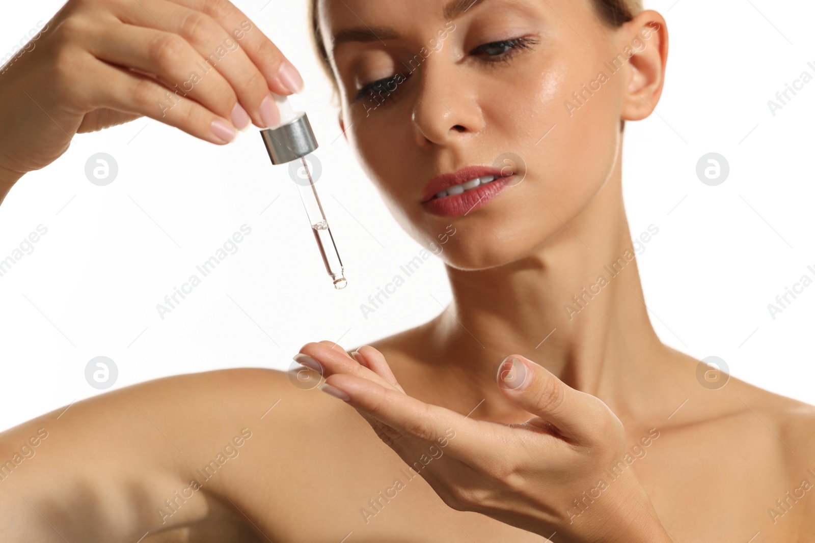 Photo of Beautiful woman applying cosmetic serum onto her hand on white background