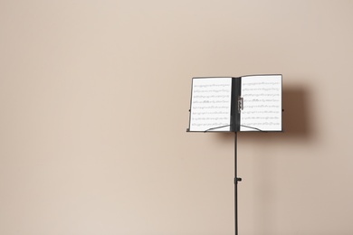 Note stand with music sheets on color background. Space for text