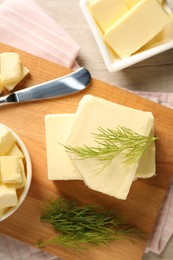 Tasty butter with dill and knife on wooden table, top view