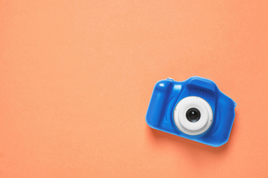 Toy camera on orange background, top view with space for text. Color of the year 2020 (Classic blue)
