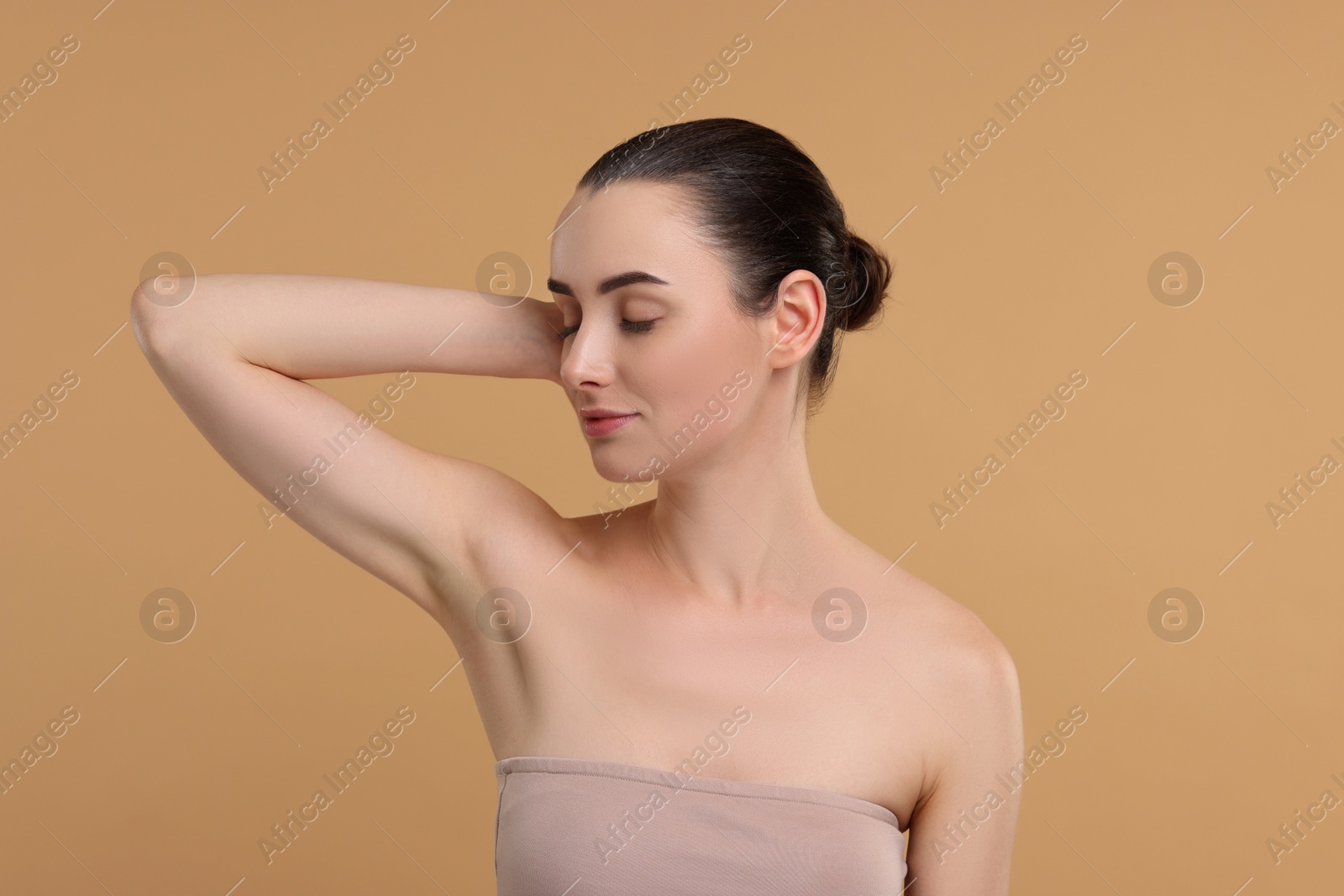 Photo of Beautiful woman showing armpit with smooth clean skin on beige background