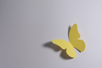 Yellow paper butterfly on light background, top view. Space for text