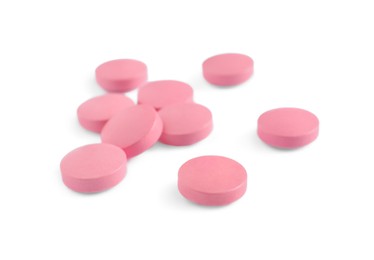 Photo of Many round pink pills on white background