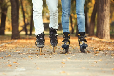 Photo of Couple roller skating in autumn park. Active leisure