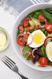Photo of Delicious salad with boiled egg, bacon and vegetables served on white wooden table, flat lay